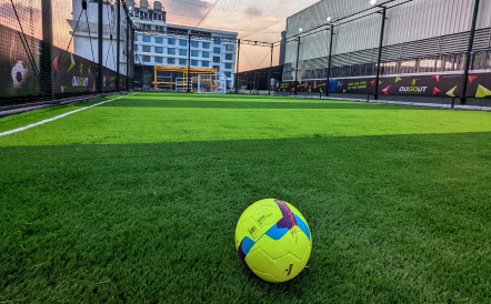 Beautiful view of an indoor football turf in Chennai with a football.