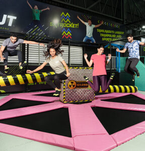 People jumping on a wipeout at a Chennai trampoline park.